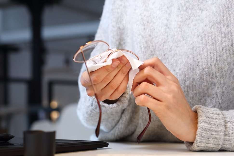 Woman cleaning her glasses with cloth