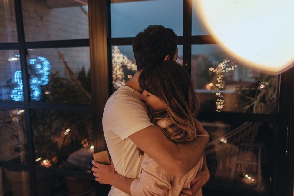 Couple hugging at window