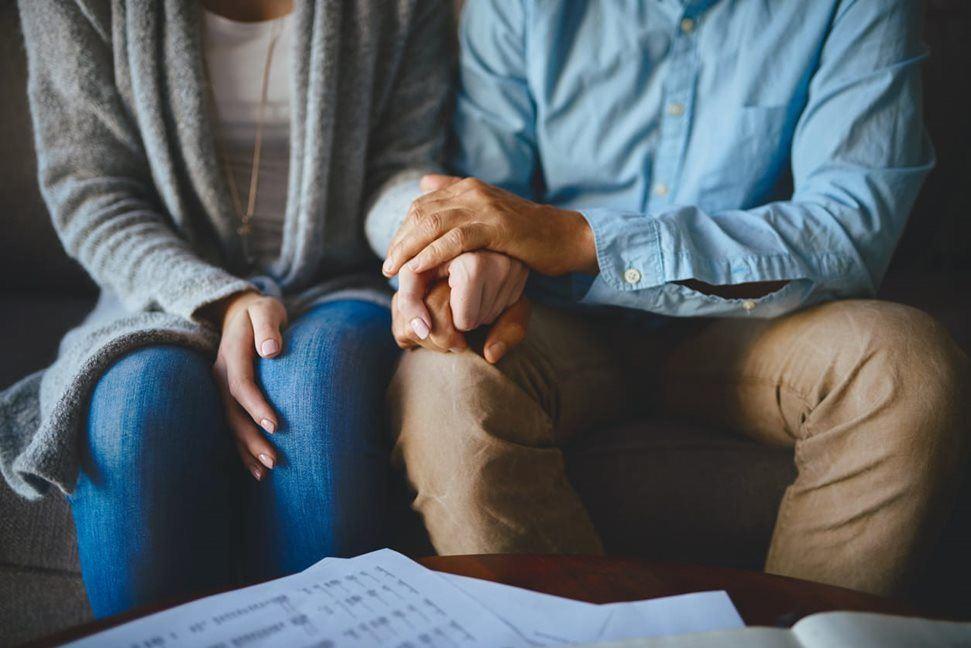 Man and woman holding hands on a couch