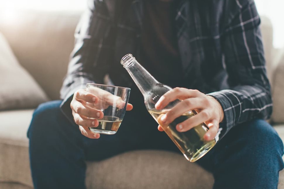 Man pouring bottle of beer into a glass