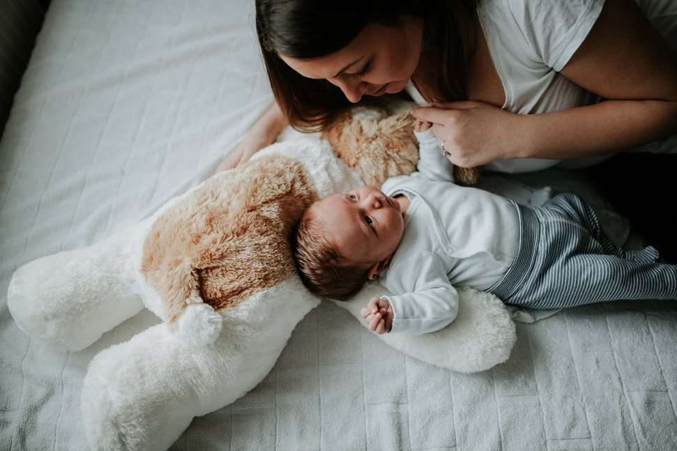 Mother and baby lying down on bed