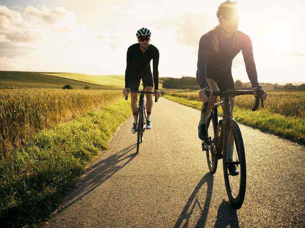 Two men cycling on country road