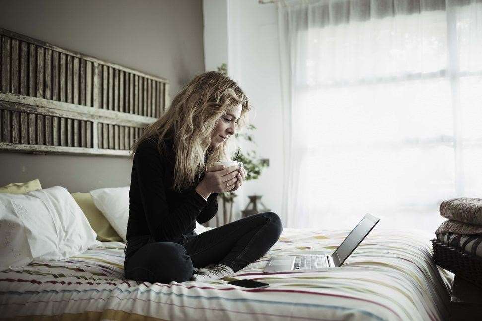 Woman with laptop on bed