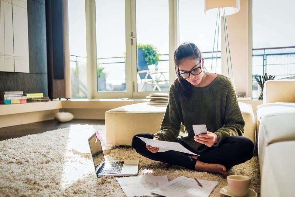 Woman sitting on floor working on laptop