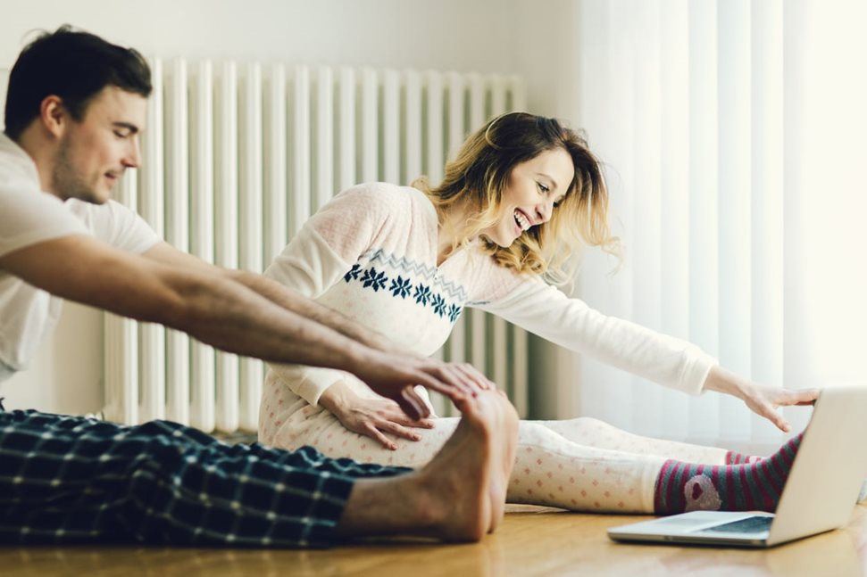 Young couple stretching at home