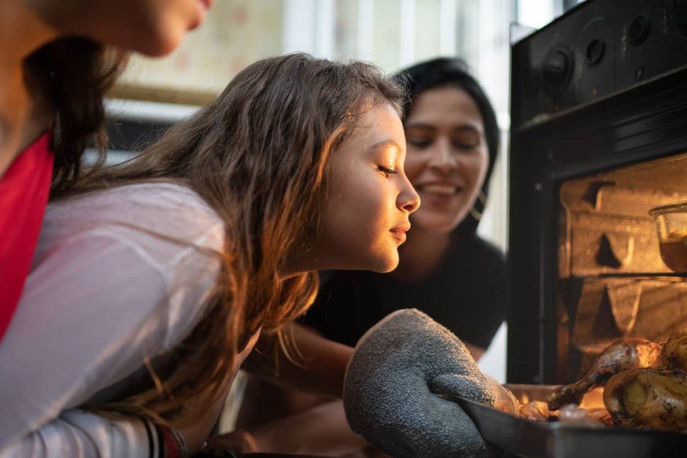 Young girl looking at the oven