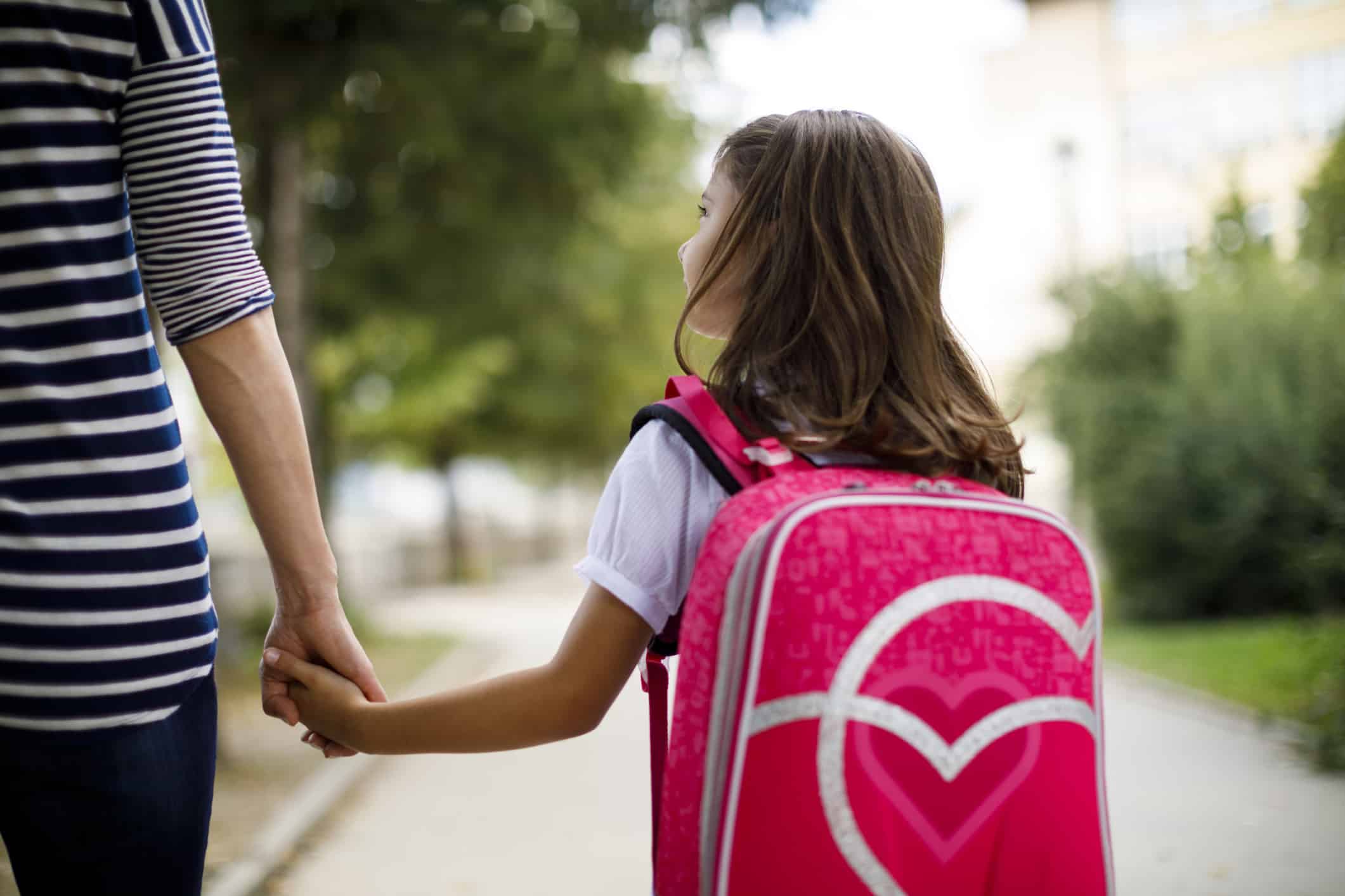 Girl walking to school with her mother