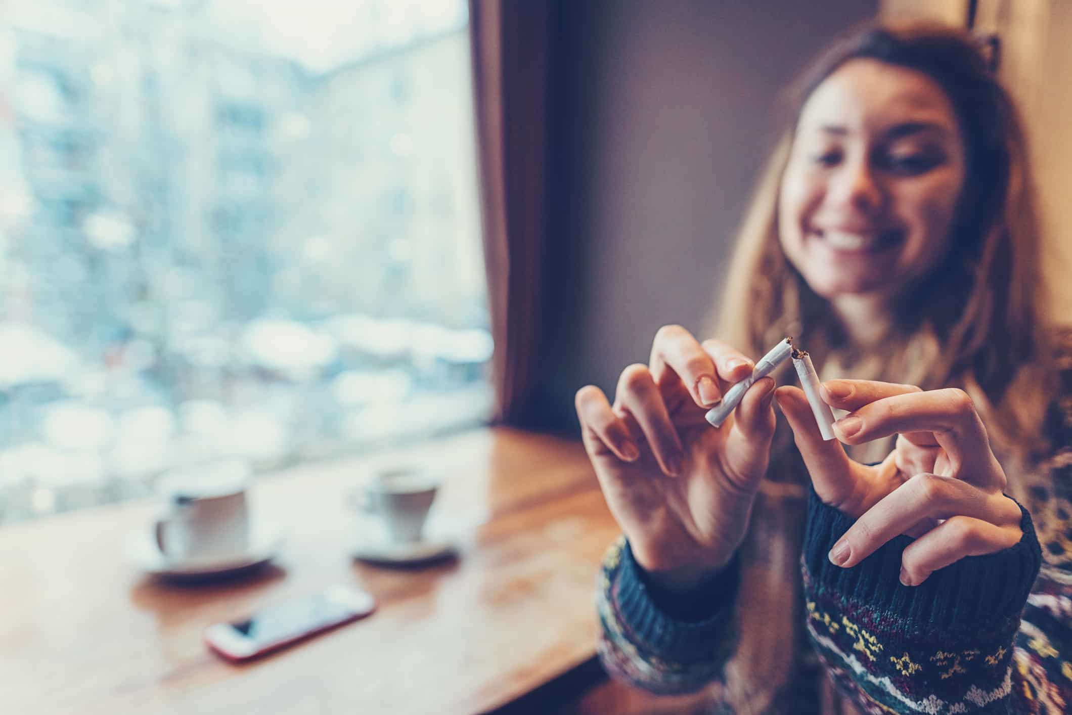 Woman breaking cigarette in half