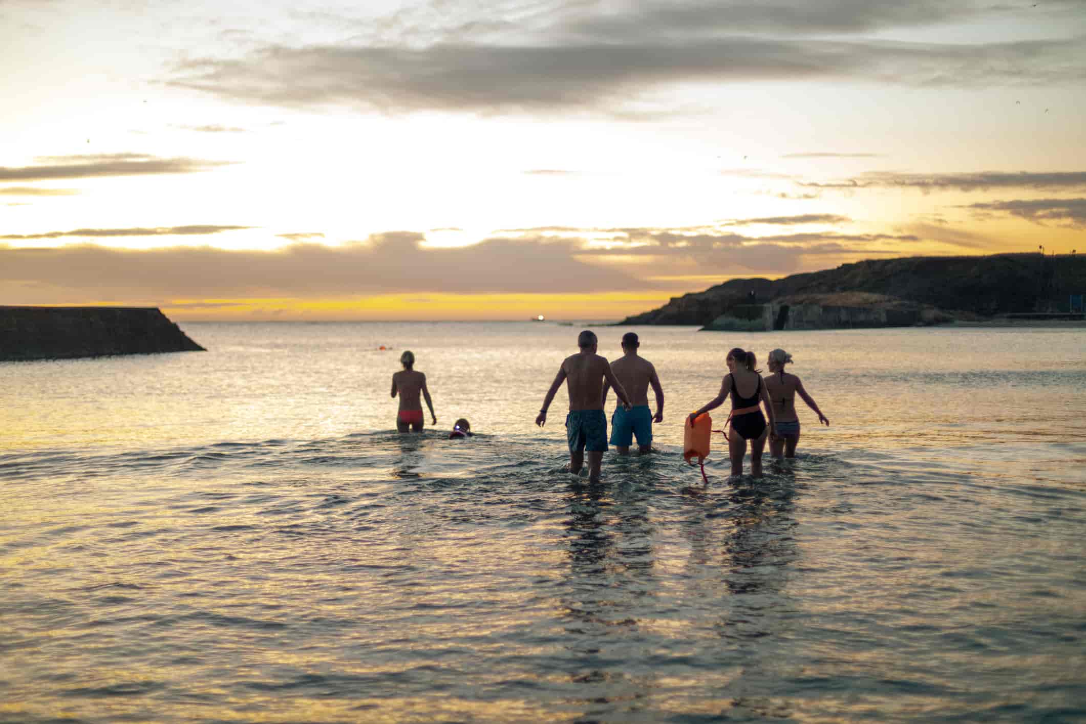 Group of people going for a sea swim