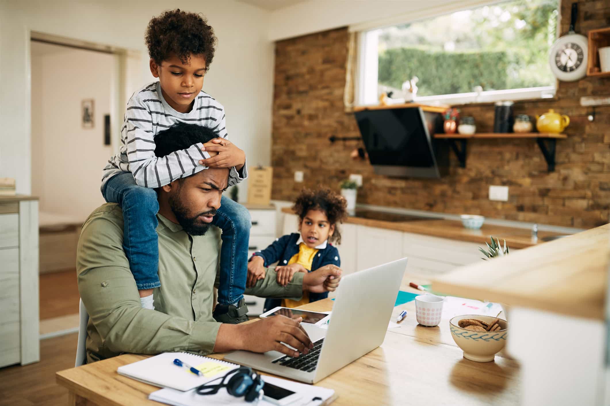 Dad working from home with kids in the kitchen