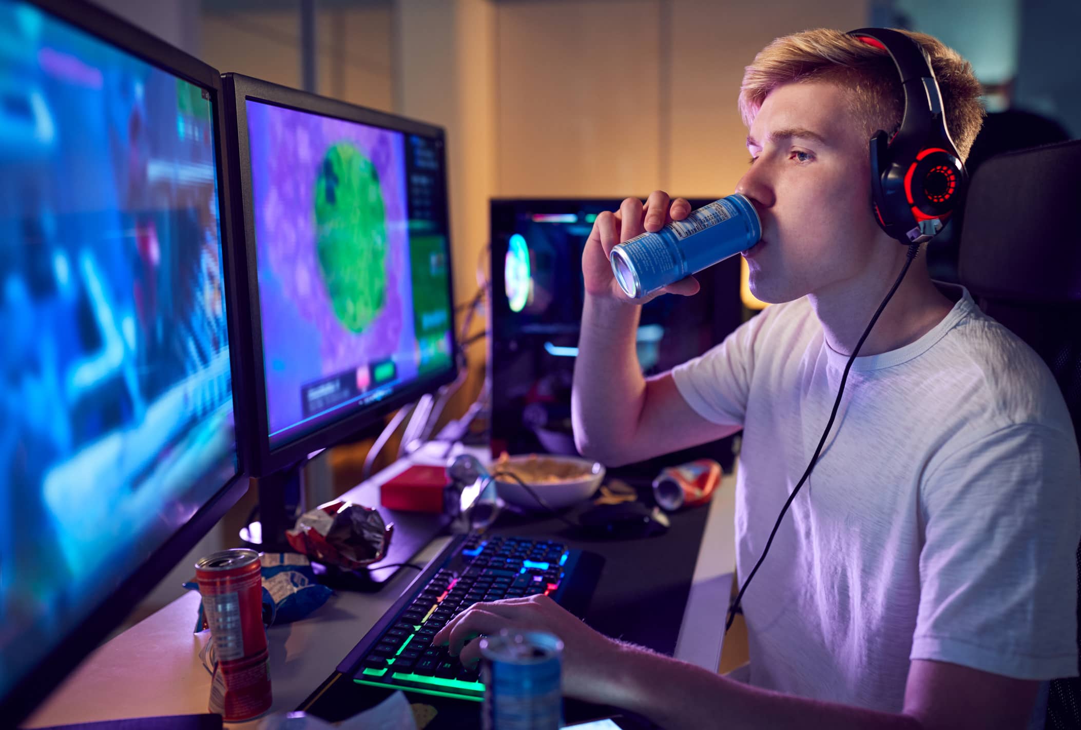 Teen boy drinking energy drink at desk