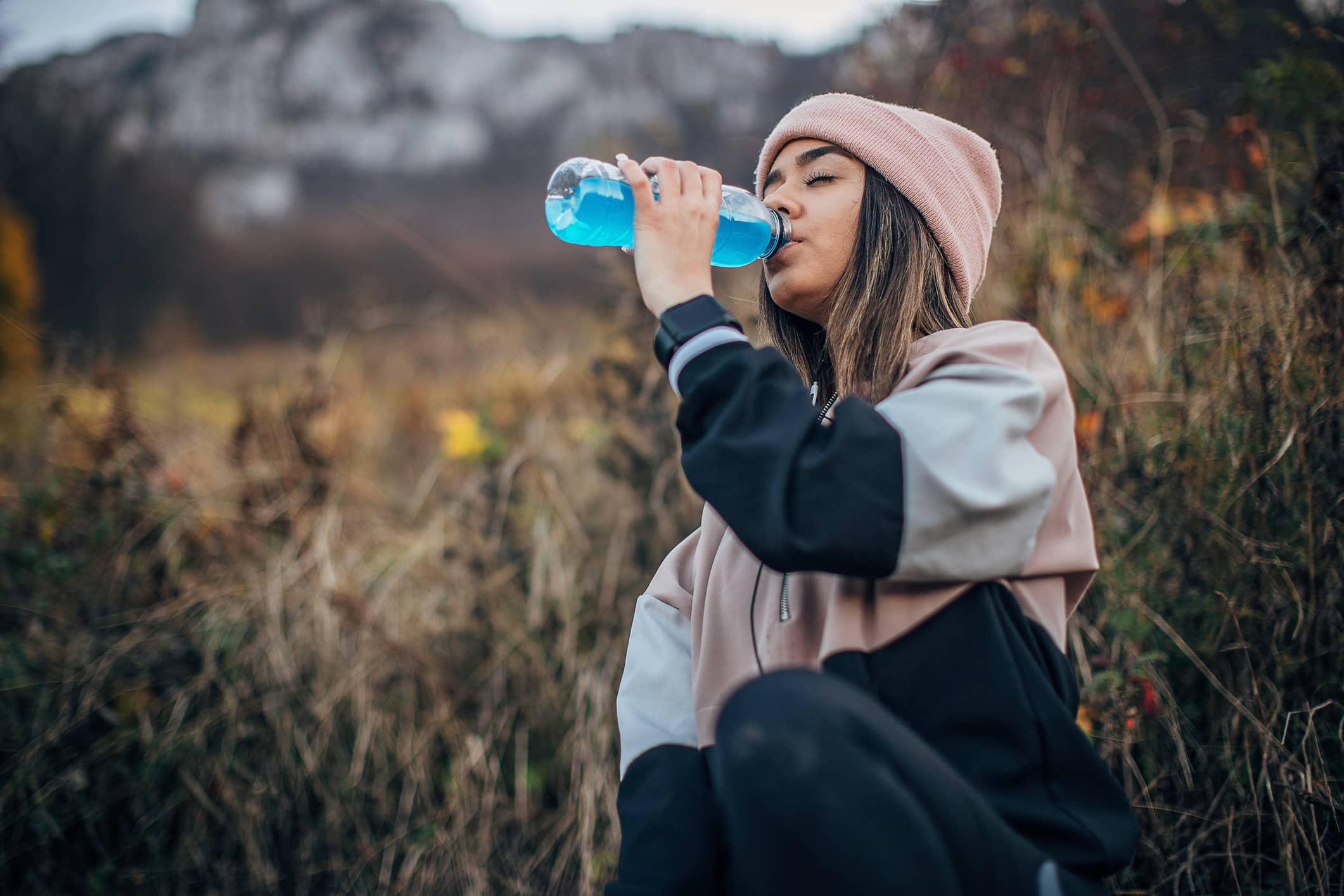 Teen girl drinking energy drink outdoors