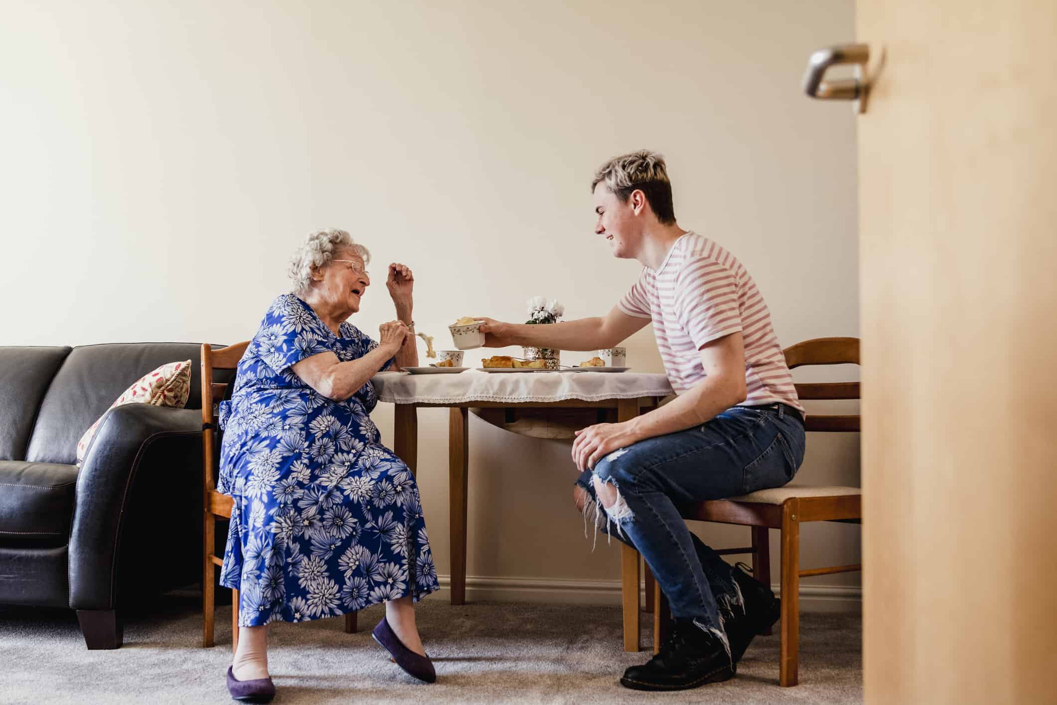 Young man having lunch with elderly lady