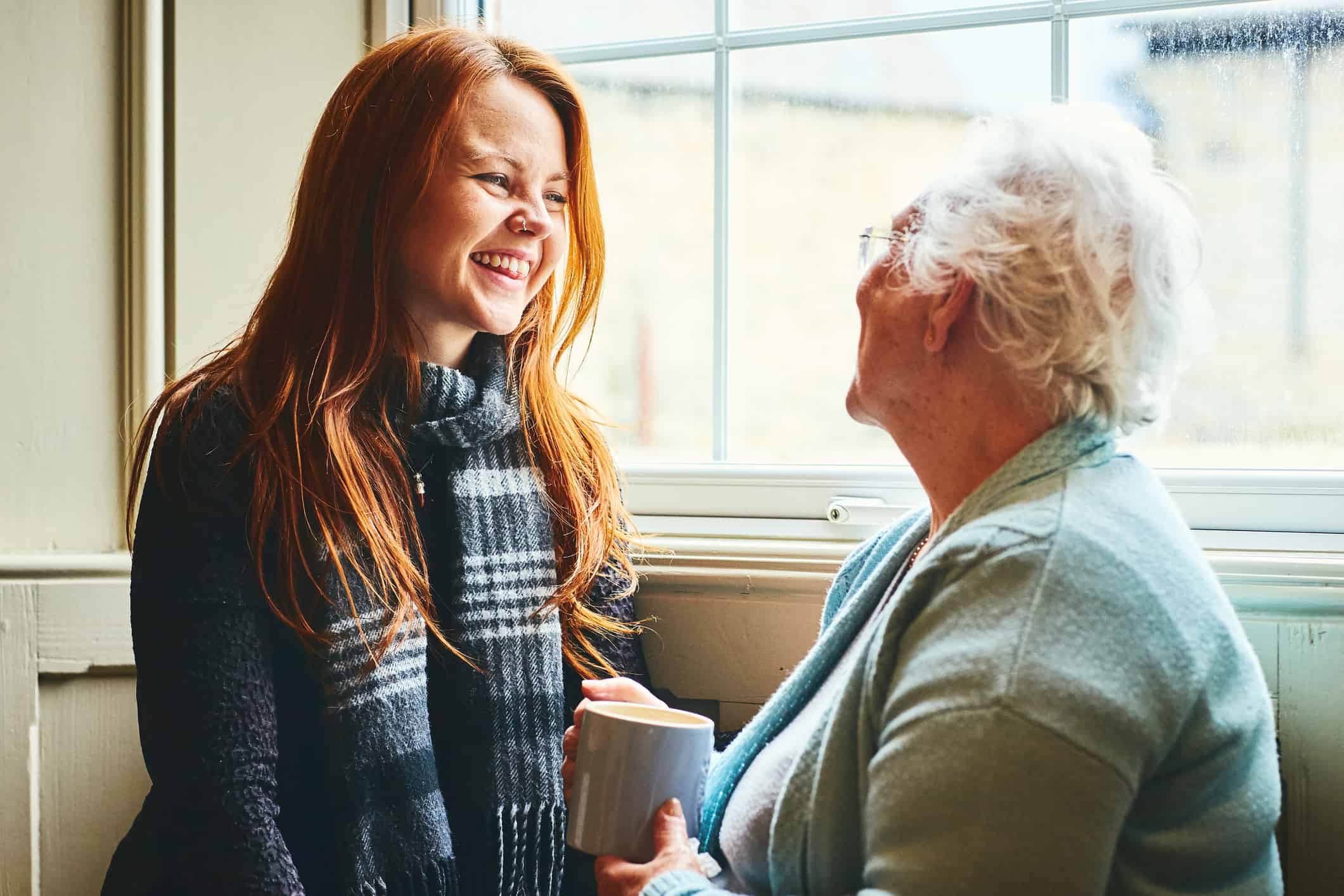 Young woman having a chat with an elderly lady