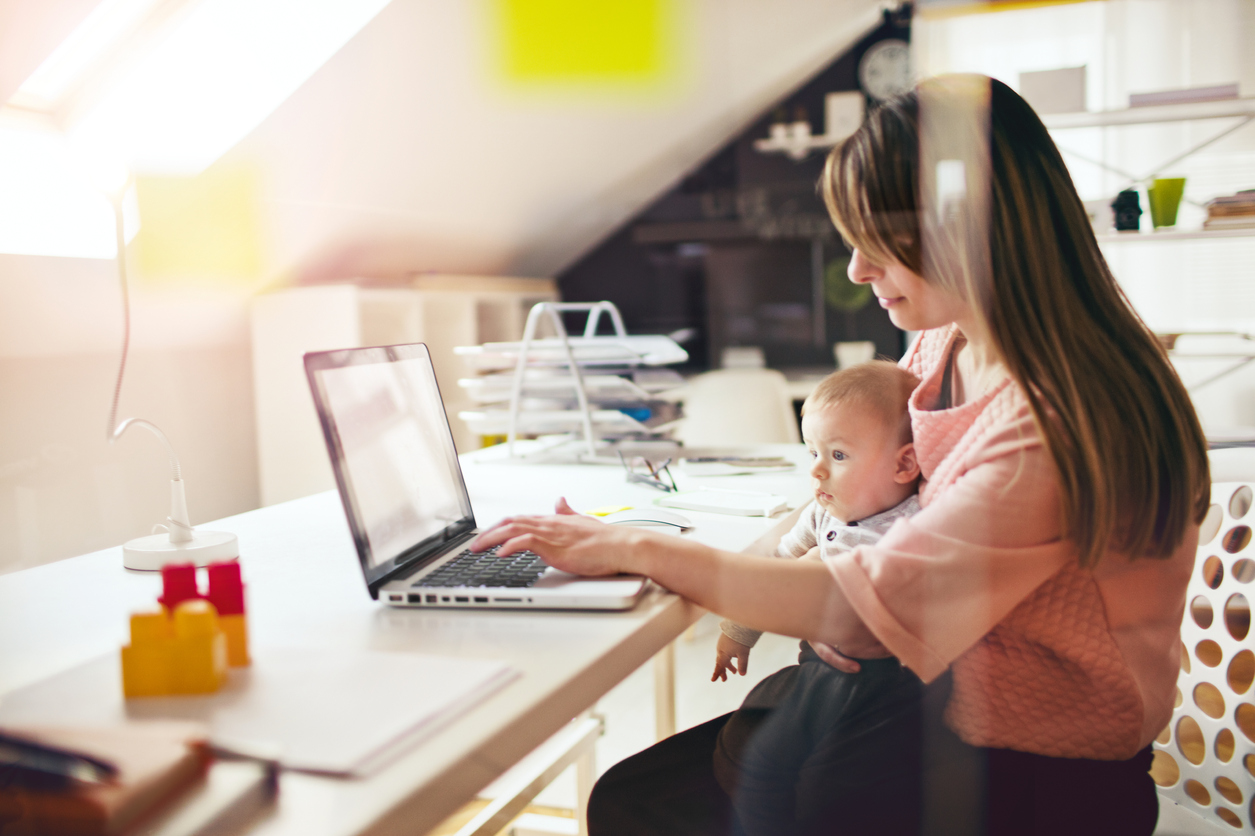 Woman minding baby while trying to work