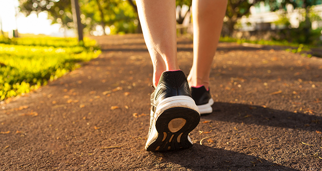 Feet of person running in park