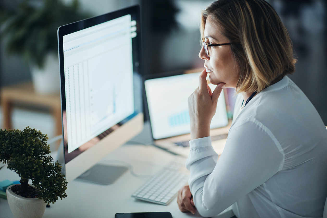 Woman looks intently at desktop screen