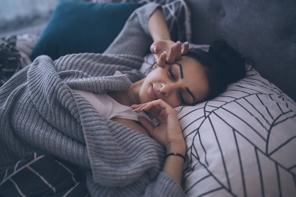 Woman stretching in bed after a good night sleep