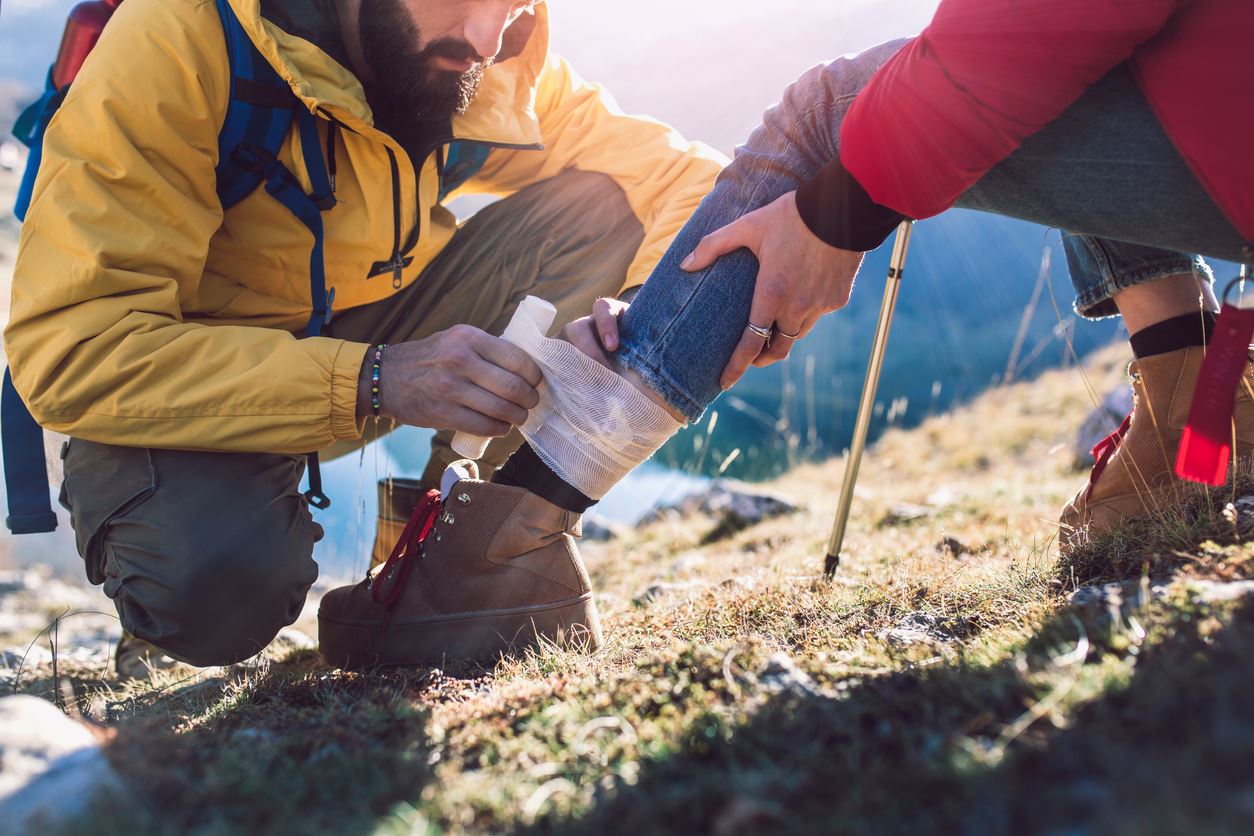 Hiker using first aid to help his friend