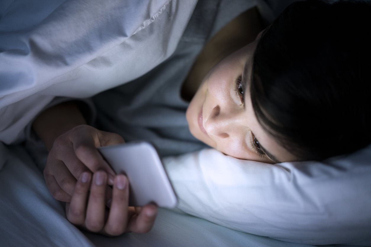 woman on phone in bed