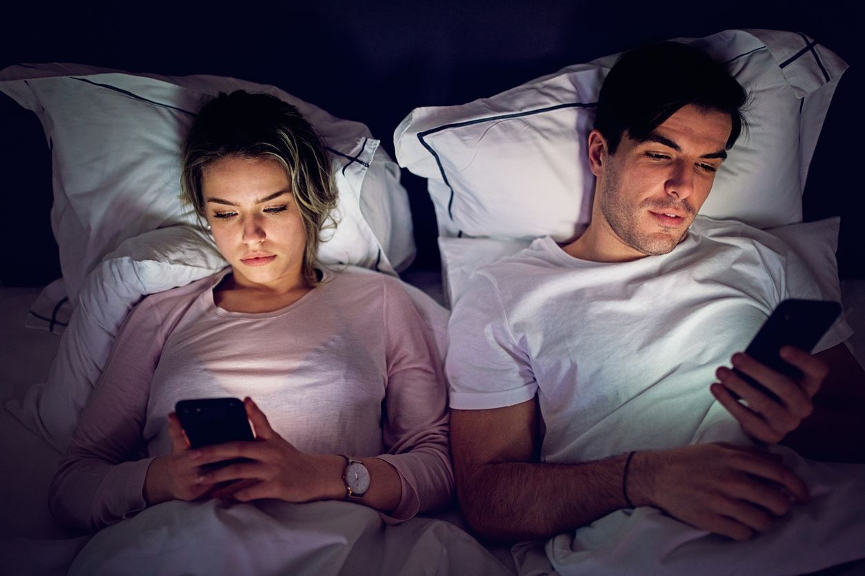 couple on phones in bed