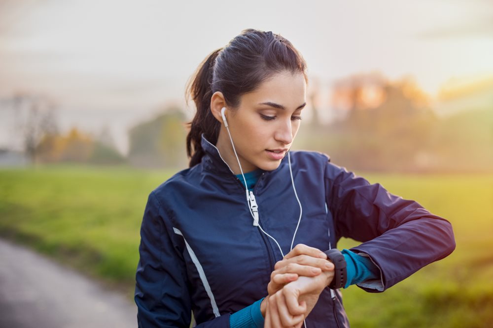Woman out for run checking her fitbit