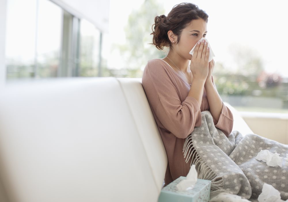 Woman with flu at home on couch
